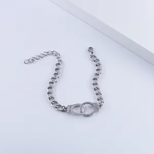 Macro detail of silver stainless steel handcuff charm with Freedom engraving on chain