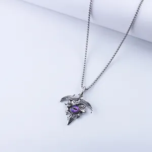 Close-up of gothic eagle pendant with purple stone on vintage silver chain necklace