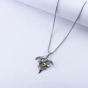 Close-up of gothic eagle wing pendant featuring a sharp silver metal finish and yellow eye