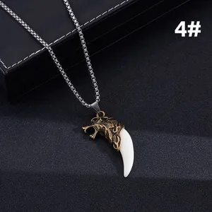 Close-up of bronze wolf head pendant with white tusk and silver beaded chain detail