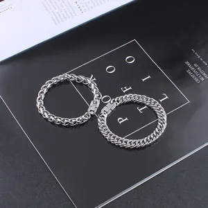 Detailed close-up of silver wheat and Cuban chain bracelets with sleek buckle clasp