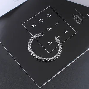 Detail of silver stainless steel wheat chain bracelet with secure buckle on magazine