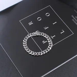 Close-up of polished silver Cuban link chain bracelet with square buckle on black background