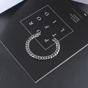 Detailed view of silver Cuban link bracelet with square clasp on black portfolio