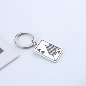 Llavero de As de Picas minimalista en metal con anillo de acero sobre fondo azul