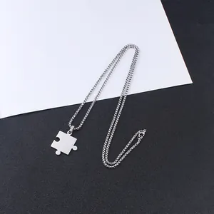 Detailansicht eines silbernen Puzzle-Anhängers an einer Gliederkette aus Edelstahl