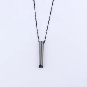 Detailed view of black stainless steel meditation whistle pendant with size dimensions