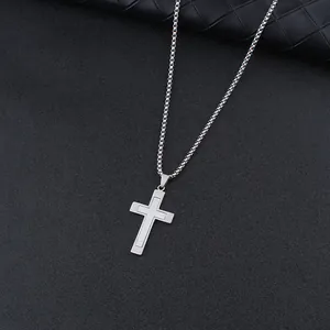 Detailed macro view of a silver double-layered stainless steel cross pendant on a box chain