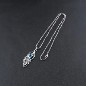 Macro shot of retro feather pendant with blue evil eye stone on a vintage silver ball chain