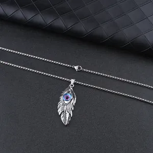 Detailed close-up of a silver feather necklace with a mystic blue devil eye pendant