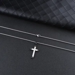 Detail of two-tone stainless steel cross pendant with black and silver layered finish