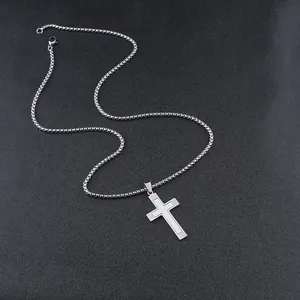 Detail of silver dual-layer cross pendant with square box chain on black background