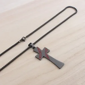 Detail von schwarzem Baseball-Kreuzanhänger mit roten Nähten auf Holzgrund