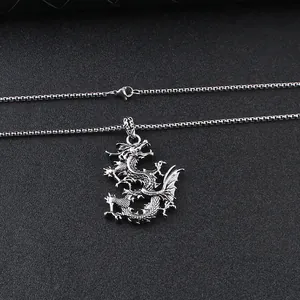 Macro shot of silver dragon pendant showing detailed scales and intricate claws on box chain