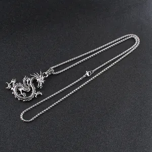 Detailed close-up of a silver dragon claw pendant with a vintage finish on a black texture