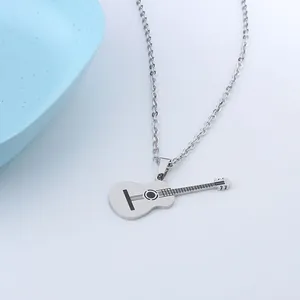 Detail of silver guitar pendant with black engraved strings and polished steel finish
