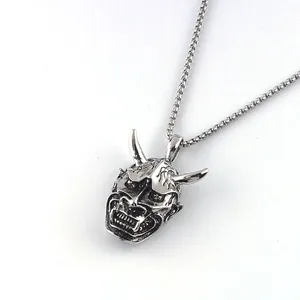 Detailed view of a vintage silver Hannya mask pendant on a box chain for men