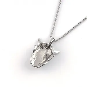 Detail of silver bull head pendant with box chain showing matte punk metal texture