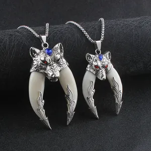 Detail of dual wolf head pendants in two sizes with red and blue gem accents on silver chain