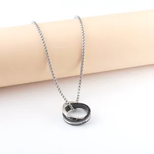 Detaillierte Nahaufnahme des Doppelring-Anhängers an einer Edelstahl-Halskette in Silber