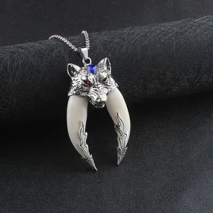 Detail of wolf head pendant with blue heart crystal and dual ivory-style tusks