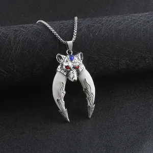 Close-up of silver wolf head necklace with red eyes and white double tusks detail