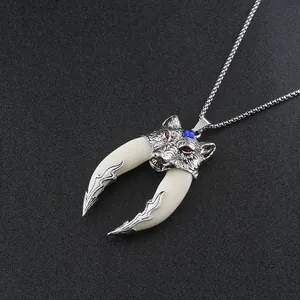 Close-up of wolf head pendant with red eye crystals and bone tusks on steel chain