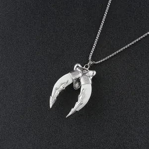 Detail of vintage double wolf tooth pendant with ornate silver metal and box chain