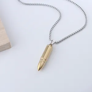 Detalle del colgante hueco en forma de bala dorada con cadena de bolas de acero plateado