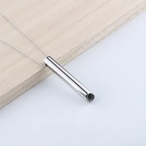 Primer plano del colgante cilíndrico de acero inoxidable pulido para meditación y respiración