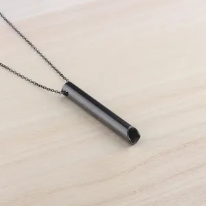 Primer plano del collar de respiración de acero inoxidable negro sobre madera clara