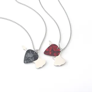 Dettaglio macro dei ciondoli a plettro per chitarra rock in marmo nero e rosso con catene