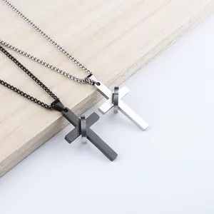 Nahaufnahme von silbernen und schwarzen Kreuzanhängern aus Edelstahl mit Metallringen