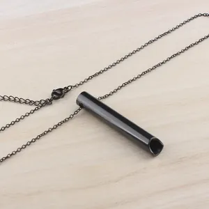 Detalle de colgante cilíndrico minimalista de acero inoxidable negro con cadena fina