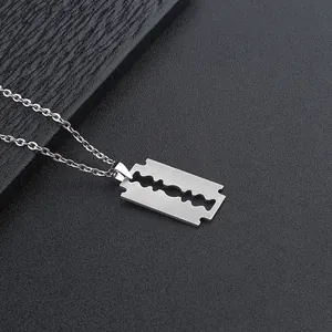 Detail shot of a brushed stainless steel razor blade pendant on a punk chain necklace