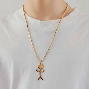 Close-up of golden stickman pendant necklace with a funny gesture on white cotton t-shirt