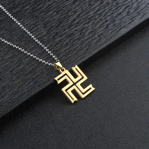Detailed view of the gold Manji pendant with a sleek silver bead chain on black background