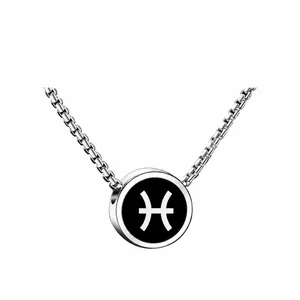 Dettaglio macro del ciondolo zodiacale Pesci in argento con inserto nero e catena box