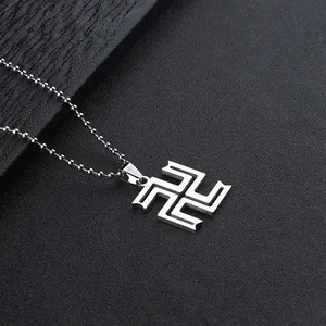 Detail of silver stainless steel swastika pendant with ball chain on dark background