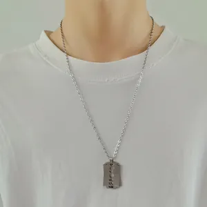 Men's hip hop razor blade pendant necklace in silver finish worn on a white t-shirt