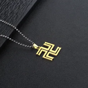 Detailed view of the gold Manji pendant on a silver bead chain with textured background