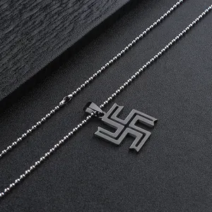 Detail of manji symbol pendant on silver ball chain with dark textured background