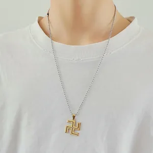 Close-up of a gold metal character pendant with a silver ball chain on a white shirt