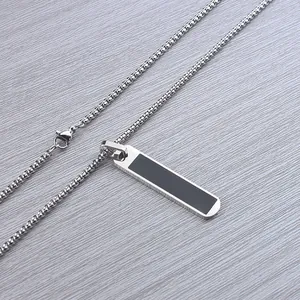 Detail shot of the rectangular stainless steel pendant with black inlay on a box chain