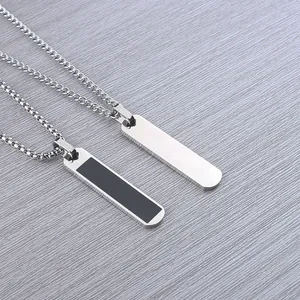 Detailed view of two stainless steel rectangular pendant necklaces with black inlay
