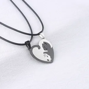 Macro detail of black and silver stainless steel couple heart cat puzzle pendants