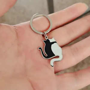 Dettaglio del portachiavi gatti bianco e nero tenuto in mano per la misura