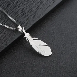Detailed macro view of silver steel feather pendant with intricate textured feather engraving