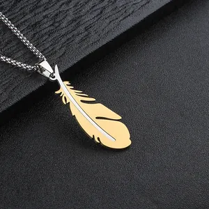 Macro detail of bicolour gold and silver feather pendant necklace on leather background