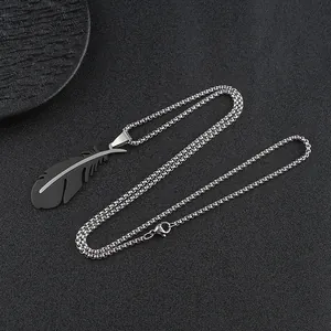 Macro detail of a black matte feather pendant with silver strip and stainless steel chain